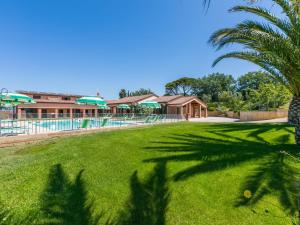 un complejo con una piscina y una palmera en Holiday Home Il Corbezzolo-2 by Interhome, en San Vincenzo