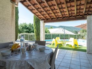 eine Terrasse mit einem Tisch, Stühlen und einem Pool in der Unterkunft Holiday Home Bois d'Astros by Interhome in Rocbaron