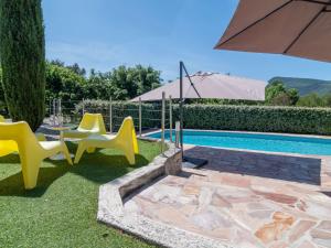 ein Pool mit gelben Stühlen und einem Sonnenschirm in der Unterkunft Holiday Home Bois d'Astros by Interhome in Rocbaron