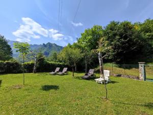 a group of chairs sitting in the grass at Holiday Home Irma by Interhome in Porlezza