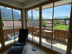 a room with a balcony with a chair and a table at Apartment Flösserstrasse by Interhome in Wallgau