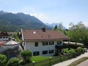 ein weißes Haus mit rotem Dach und einem Zaun in der Unterkunft Apartment Flösserstrasse by Interhome in Wallgau