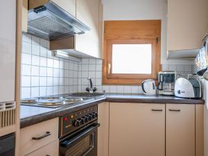 een keuken met een fornuis en een raam bij Apartment Chesa Pra d`Sura 217-10 by Interhome in Maloja