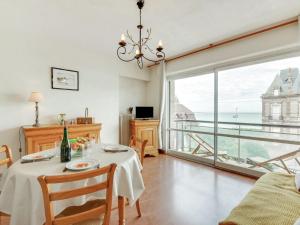 a dining room with a table and a large window at Apartment Prince Albert by Interhome in Cabourg