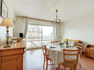 a dining room with a table with chairs and a window at Apartment Prince Albert by Interhome in Cabourg +12 photos