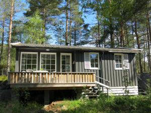 a tiny house with a deck in the woods at Holiday Home Torsteinbu - SOW118 by Interhome in Øyuvstad