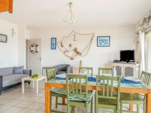 a dining room and living room with a table and chairs at Holiday Home Le Hameau des Pêcheurs 5-1 by Interhome in Mimizan-Plage