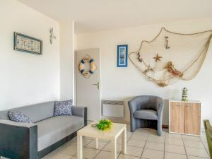 a living room with a couch and a chair at Holiday Home Le Hameau des Pêcheurs 5-1 by Interhome in Mimizan-Plage