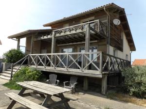 a wooden house with a wooden deck and a picnic table at Holiday Home Villa Marine by Interhome in Mimizan-Plage