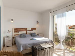 a bedroom with a bed and a large window at Holiday Home Villa Marine by Interhome in Mimizan-Plage