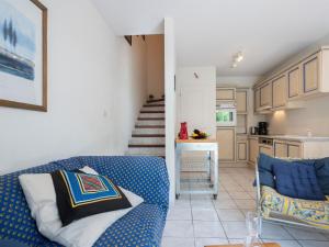 カネ・アン・ルシヨンにあるHoliday Home Villa Cassin by Interhomeのリビングルーム(青いソファ付)、キッチン
