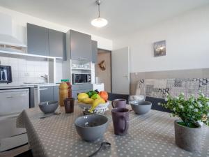 - une cuisine avec une table et un bol de fruits dans l'établissement Apartment Le Beaupré-20 by Interhome, à Canet