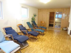 a waiting room with blue chairs and wooden floors at Holiday Home Schwänli by Interhome in Oberammergau