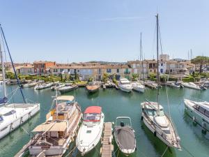 a group of boats docked in a marina with buildings at Apartment Rue de l'Amarrage by Interhome in Grimaud