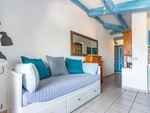 a living room with a couch with blue pillows at Apartment Rue de l'Amarrage by Interhome in Grimaud