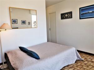 una camera da letto con un letto con uno specchio sul muro di Apartment Las Palmas 2 by Interhome a Narbonne-Plage