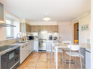 a kitchen with white cabinets and a table and chairs at Apartment Ker Marie by Interhome in Daoulas