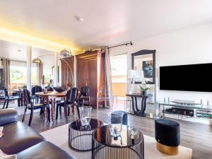 a living room with a couch and a tv at Apartment Les Patios-7 by Interhome in Saint-Tropez