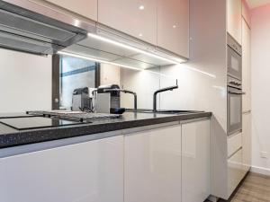 a kitchen with white cabinets and a sink at Apartment Les Patios-7 by Interhome in Saint-Tropez +19 photos