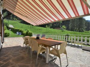 a wooden table and chairs under a canopy on a patio at Villa Villa Lucia by Interhome in Pellizzano