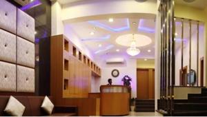 a lobby with a person sitting at a counter in a building at Hotel Durga Silverline in Jodhpur