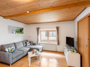 uma sala de estar com um sofá e uma televisão em Holiday Home Marion by Interhome em Saalfelden am Steinernen Meer