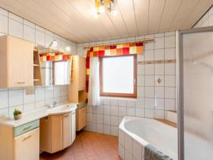 a bathroom with a tub and a sink at Holiday Home Marion by Interhome in Saalfelden am Steinernen Meer