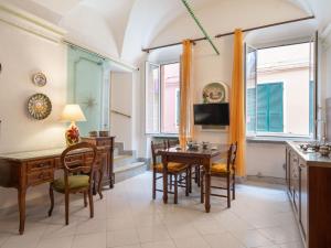 kuchnia i jadalnia z biurkiem i krzesłami w obiekcie Holiday Home Casa della Mamma by Interhome w mieście Riva Ligure
