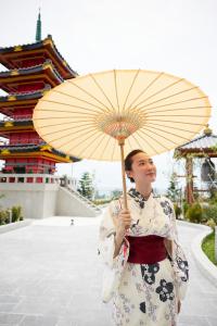 Eine Frau in einem Kimono, die einen Regenschirm hält. in der Unterkunft Da Nang - Mikazuki Japanese Resorts & Spa in Đà Nẵng