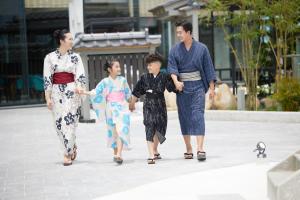 een groep van drie mensen die over een stoep lopen bij Da Nang - Mikazuki Japanese Resorts & Spa in Da Nang