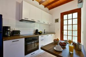kuchnia z białymi szafkami i drewnianym stołem w obiekcie Alamanos House w mieście Mesongi