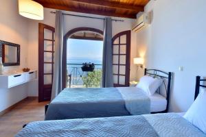 sypialnia z 2 łóżkami i widokiem na ocean w obiekcie Alamanos House w mieście Mesongi