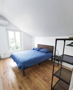 1 dormitorio con cama con sábanas azules y ventana en Le temps d'une pause''', 