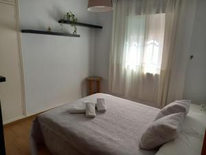 Un dormitorio con una cama blanca con toallas. en El Viajero en Sevilla, en Sevilla