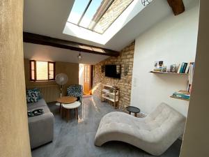 uma sala de estar com um sofá branco e uma clarabóia em La Mansarde De L Abbaye em Cluny