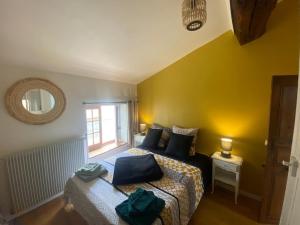 a bedroom with two beds and a window at La Mansarde De L Abbaye in Cluny