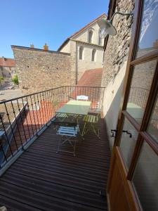 uma varanda com uma mesa e cadeiras em La Mansarde De L Abbaye em Cluny