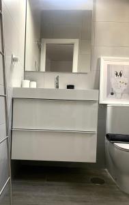 biała łazienka z umywalką i toaletą w obiekcie Apartamento en el Centro con Parking w mieście Tarifa