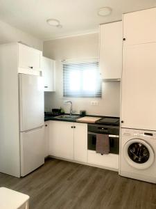 kuchnia z białymi szafkami i zmywarką do naczyń w obiekcie Apartamento en el Centro con Parking w mieście Tarifa