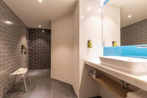 uma casa de banho com um lavatório branco e um espelho. em Holiday Inn Express Brussels-Grand-Place, an IHG Hotel em Bruxelas