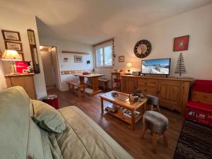 a living room with a couch and a table at Parnasse 413 - Appartement centre in La Clusaz