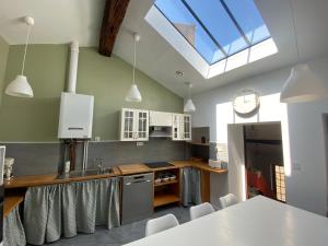 a kitchen with a sink and a table with chairs at La Mansarde De L Abbaye in Cluny