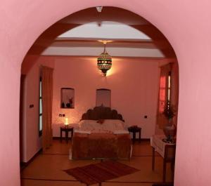 a bedroom with a bed and a chandelier at Room in Guest room - Room in villa Lair De La Mer in Sidi Kaouki