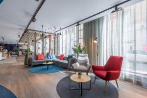 a lobby with couches and chairs and windows at Holiday Inn Express Brussels-Grand-Place, an IHG Hotel in Brussels