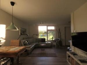 een woonkamer met een bank en een tafel bij in de Boomgaard in Burgh Haamstede