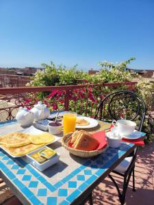 een tafel met ontbijtproducten op een balkon bij Riad Lorsya in Marrakesh