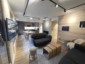 a living room with a couch and a table at BOREAL Bel appartement village et pistes in La Clusaz