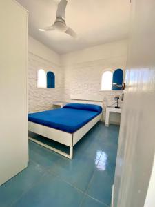 a bedroom with a bed and a blue floor at Villette di Cala Creta in Lampedusa