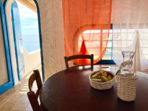 a table with a basket of fruit and a glass at Villette di Cala Creta in Lampedusa