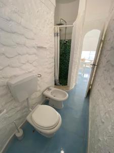 a white bathroom with two toilets and a sink at Villette di Cala Creta in Lampedusa +35 photos